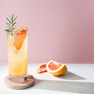 Grapefruit Paloma Cocktail garnished with a rosemary sprig